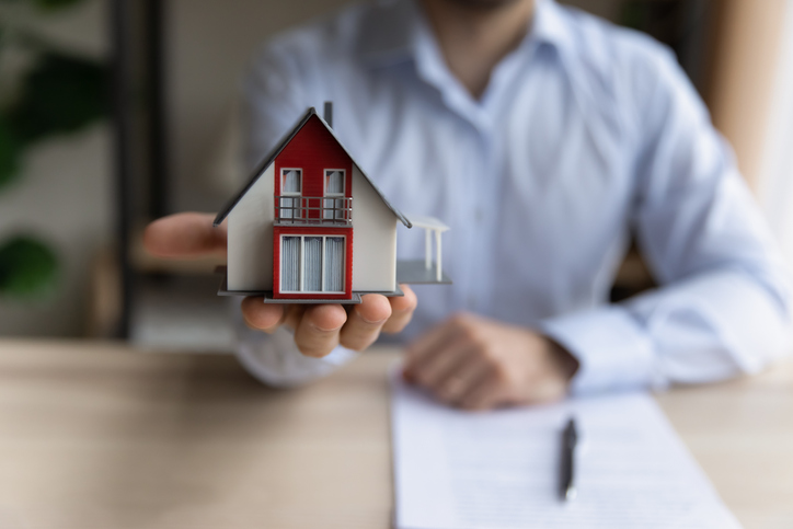 Man realtor holding tiny house layout close up view